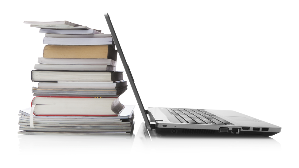 Open laptop screen leaning against a stack of books