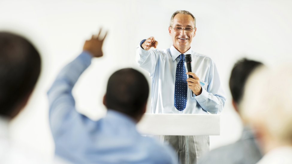 Group of businesspeople on a lecture asking questions to the public speaker.