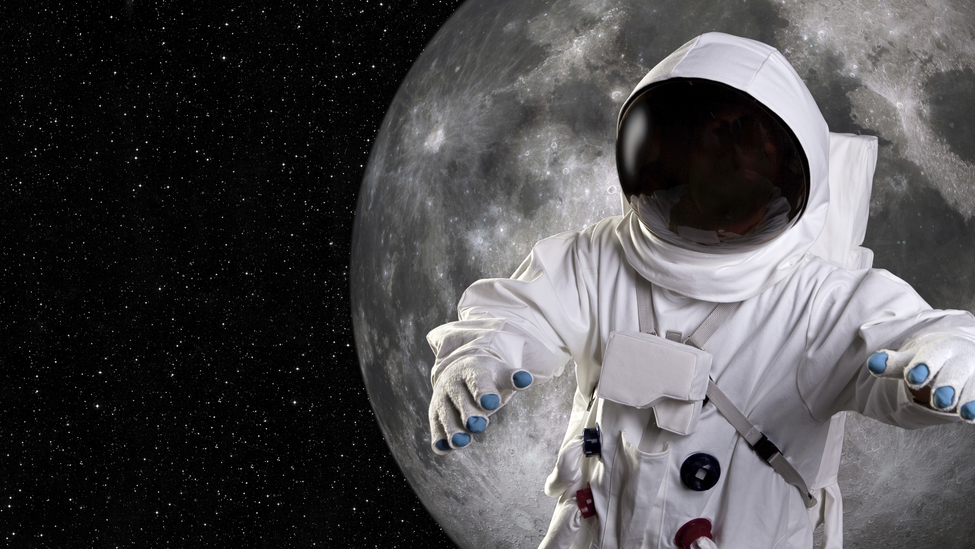 An astronaut floats in space with the moon behind them.