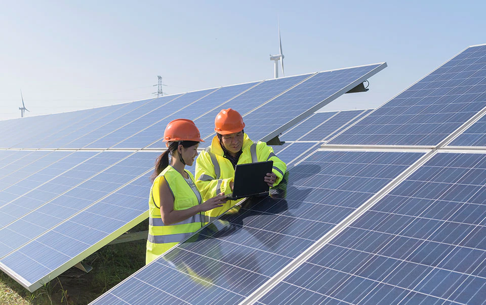 2 professionals looking at solar panels.