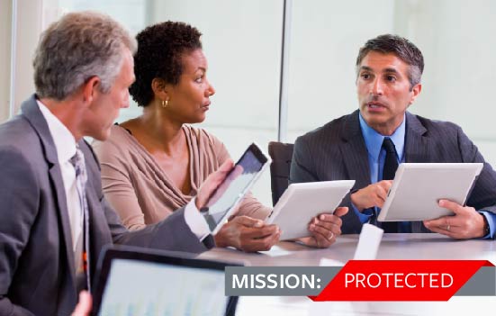 3 professionals gathered around table looking at tablets.