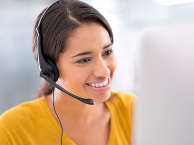 Smiling woman wearing headset in call center. 