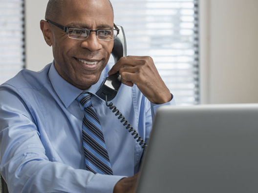 Executive in an office consulting with clients on the phone.