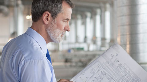 Man looking at building design plans.