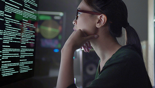 A girl looking at the hacker attack on the screen.