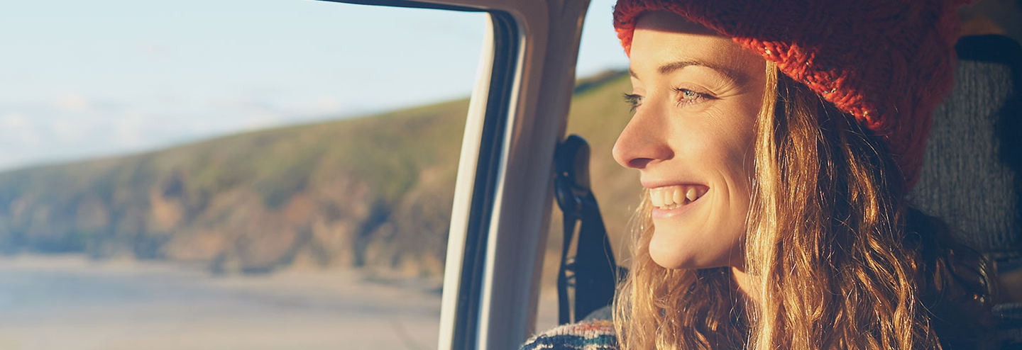 Carefree woman smiles while on a road trip.