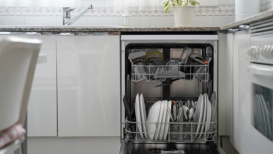 An open dishwasher full of dishes in a modern kitchen.