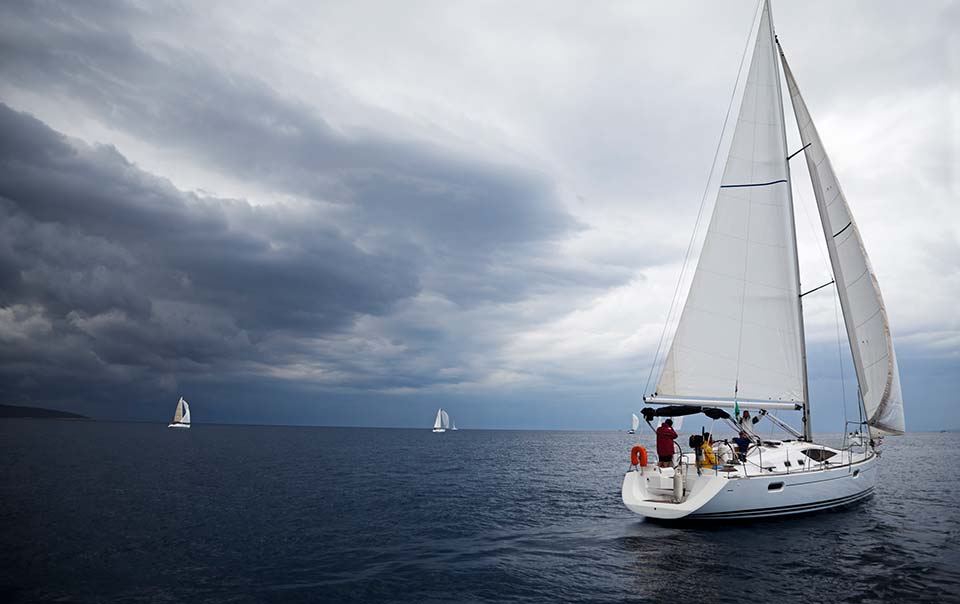 Boat sailing away from oncoming storm.