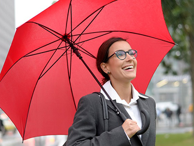 Smiling businesswoman with red umbrella.