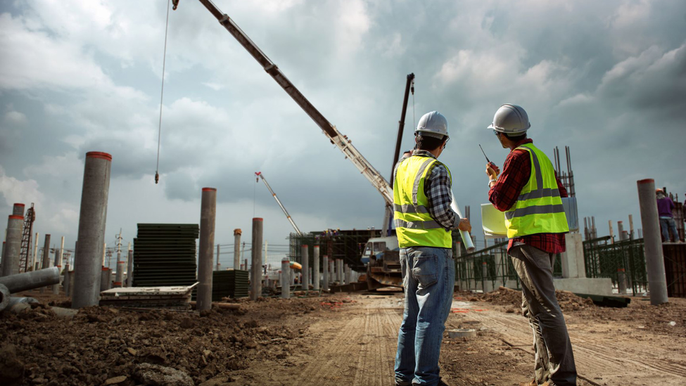 Construction workers at a construction site with cranes