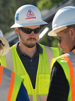 Three construction workers discussing project plan.