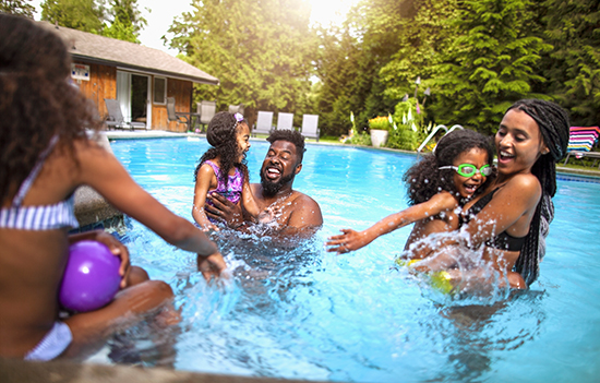 family playing and splashing in the pool