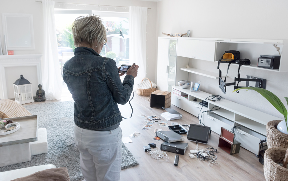 Woman taking pictures of damaged apartment 