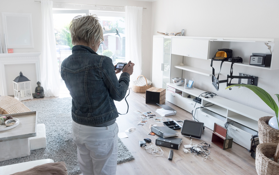 Woman taking pictures of damaged apartment