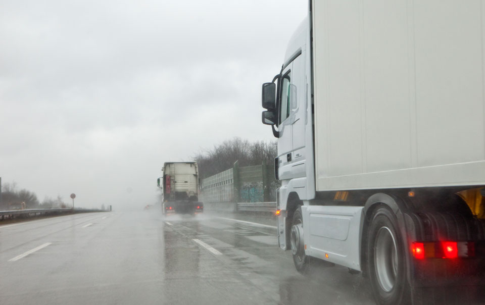 2-trucks-driving-in-the-rain