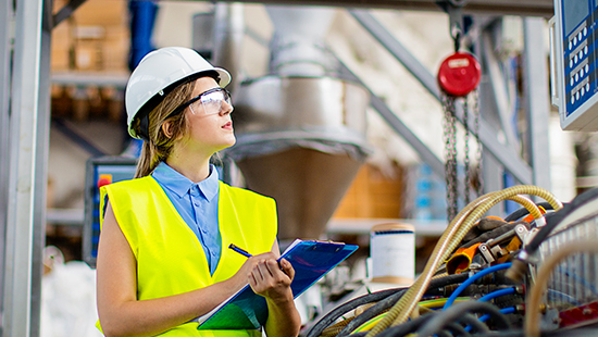 Facilities manager in safety gear does a visual check of equipment. 