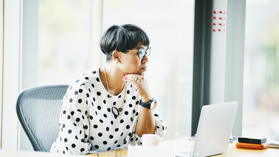 Mature businesswoman working on laptop at workstation in office