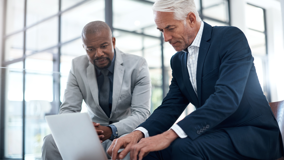 hot of two businessmen working together on a laptop in an office