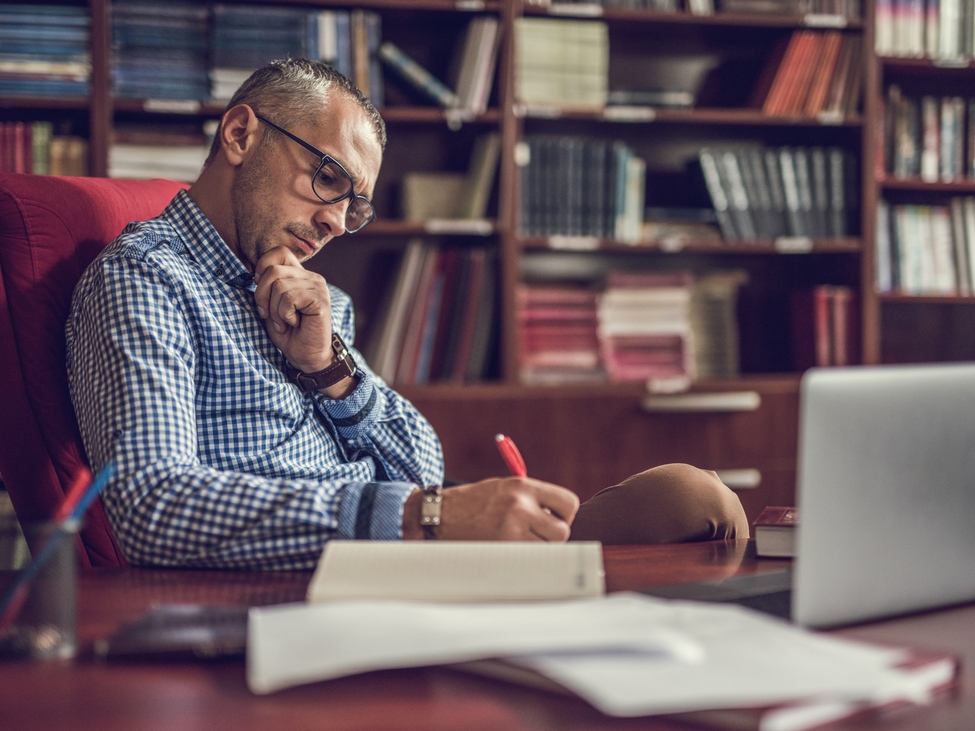 Male manager taking notes in home office