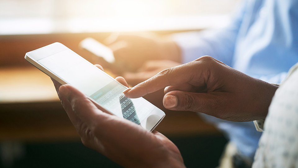 Closeup shot of two unrecognisable businesspeople using digital devices in an office