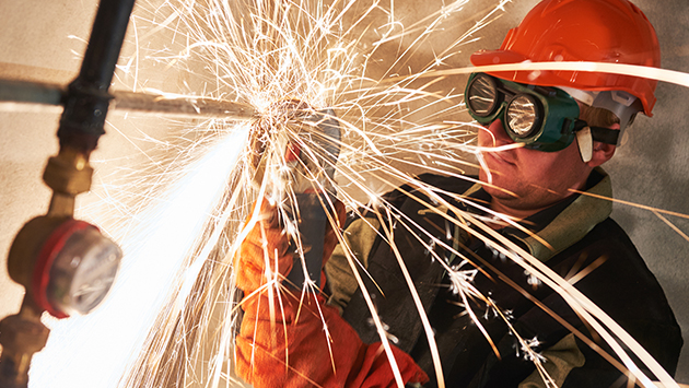 Construction worker welding as part of hot work operations.