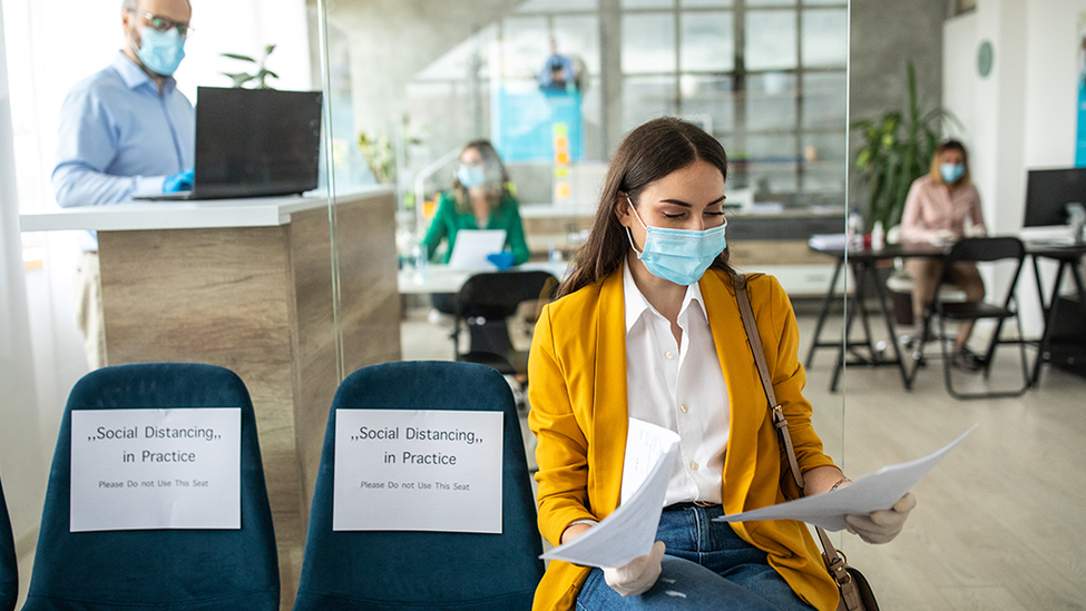 woman wearing a mask and sitting in a waiting room