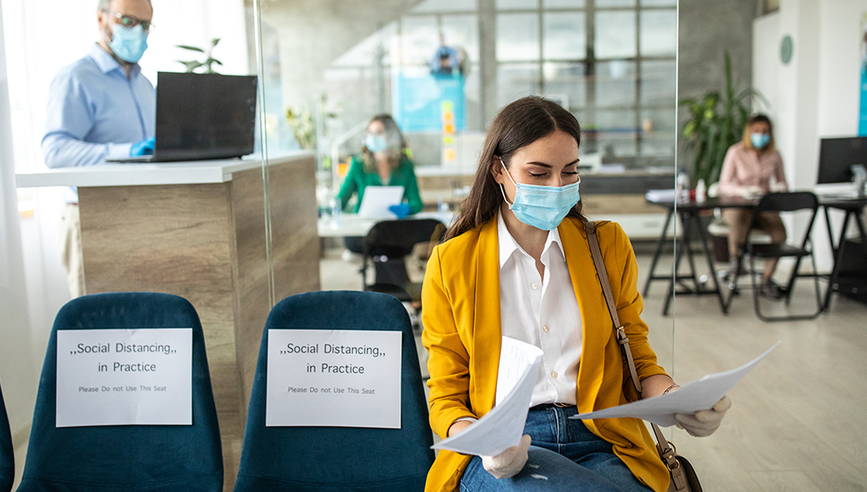 woman wearing a mask and sitting in a waiting room