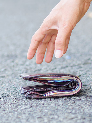 A fallen wallet on the ground gets picked up.