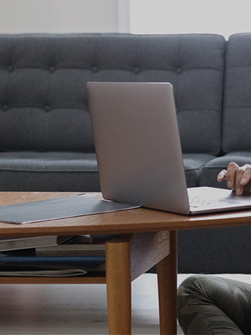 Homeowner reads about home insurance tips while sitting in her living room.