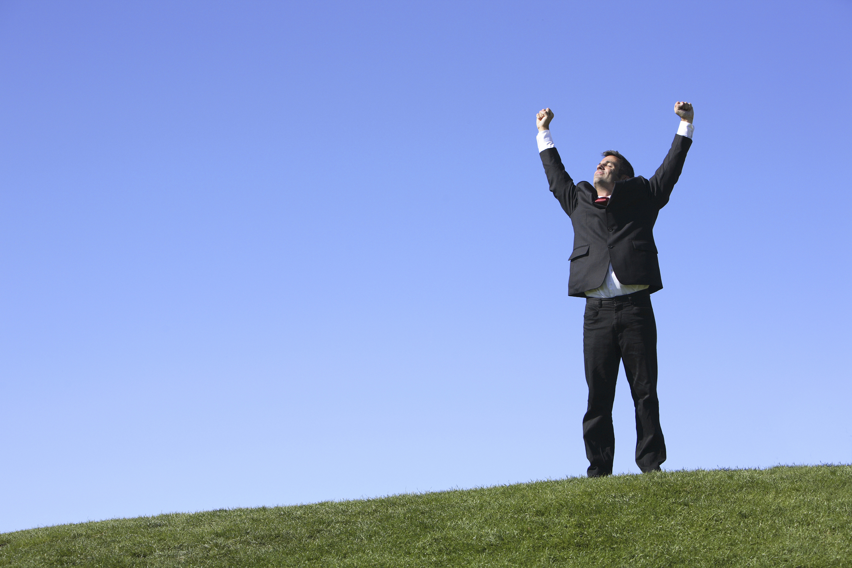 Businessman outdoors with hands up in air