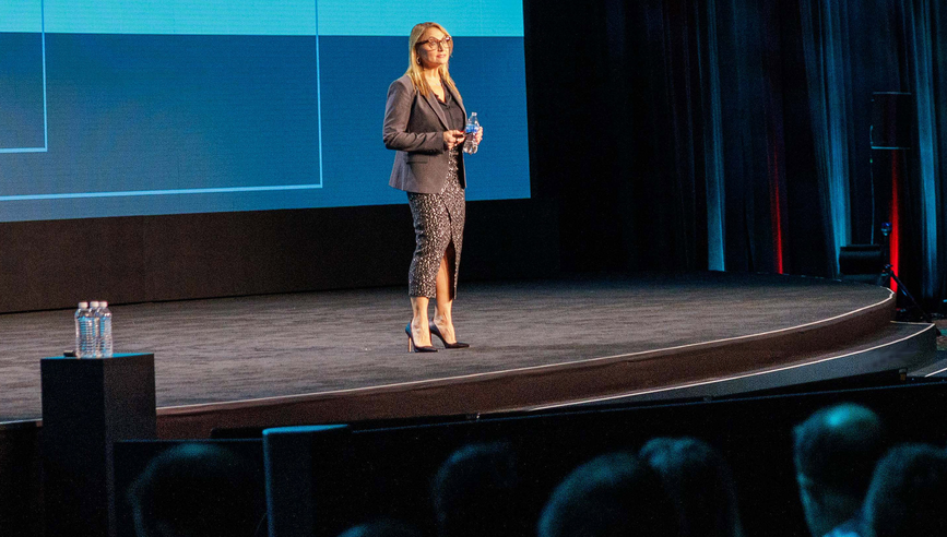 Mojgan Lefebvre giving a speech on a stage.