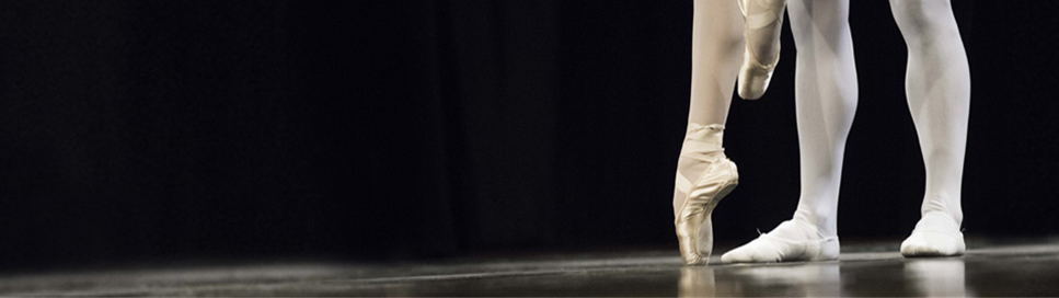 Male and female ballerina feet on stage.