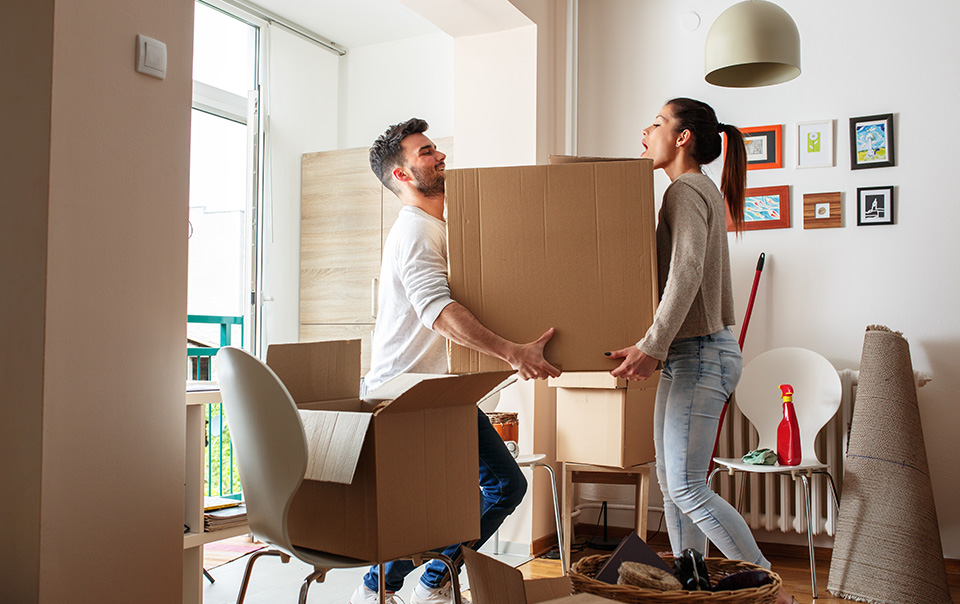 couple moving boxes themselves into new apartment