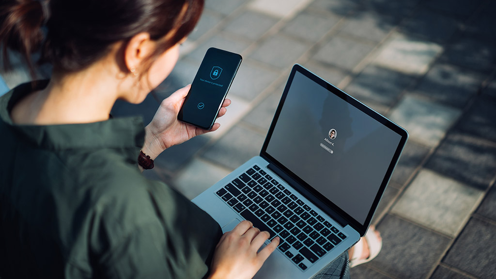 Woman uses multifactor authentication on her phone to login to her computer.