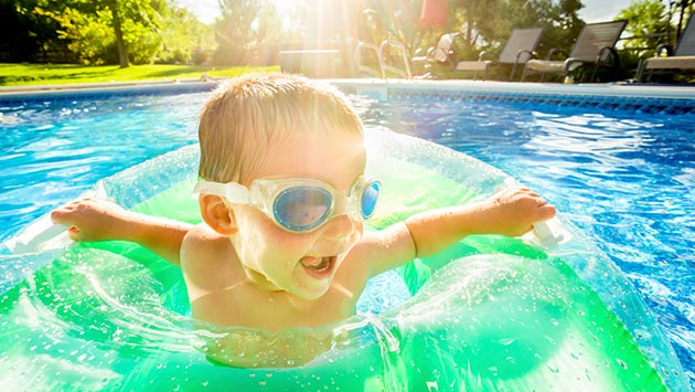 Child with goggles on swimming.