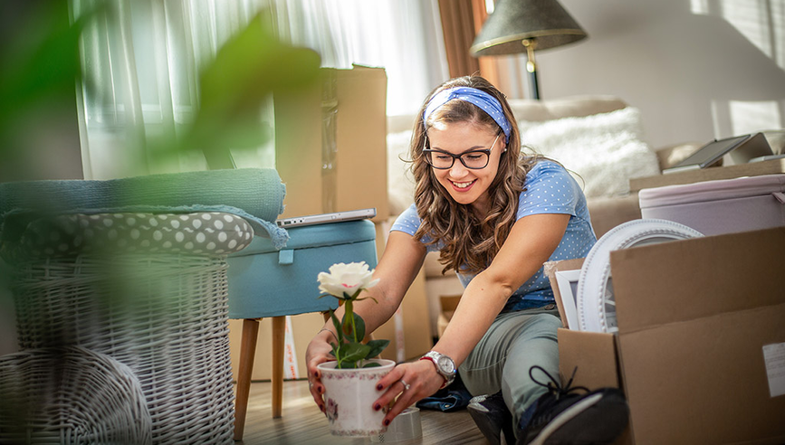 Young woman moves things to a new home.