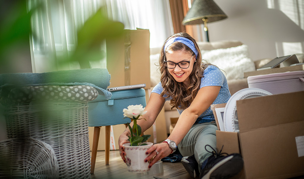 Young woman moves things to a new home