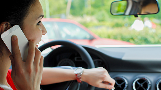 Woman driving distracted while talking on the phone.