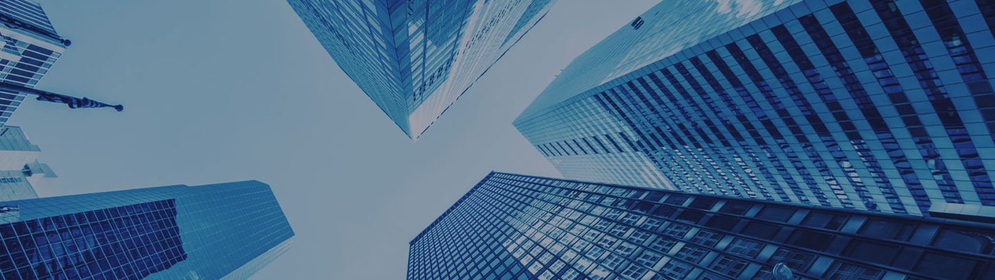 A blue skyward view surrounded by tall glass buildings.