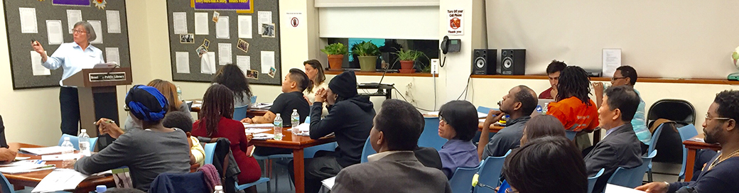 Instructor teaching group of people sitting in desks.