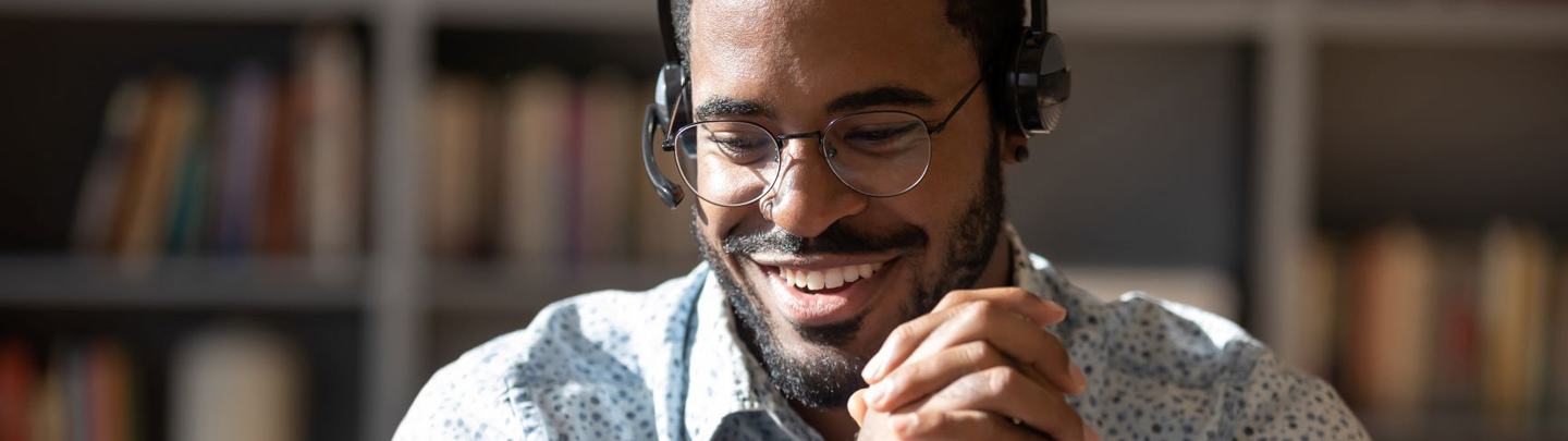 Smiling biracial male telemarketer consult client online