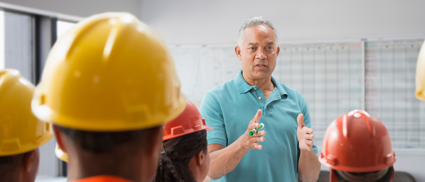 Speaker giving presentation to construction workers