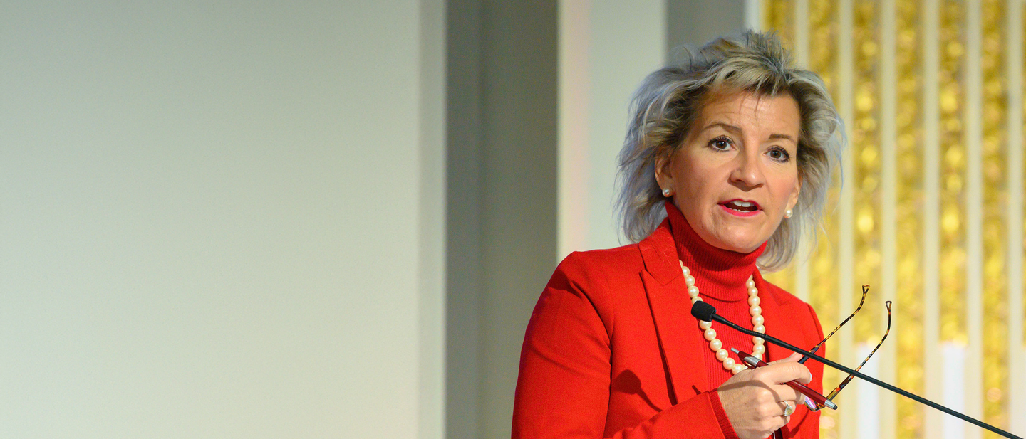 Joan Woodward speaking at a podium