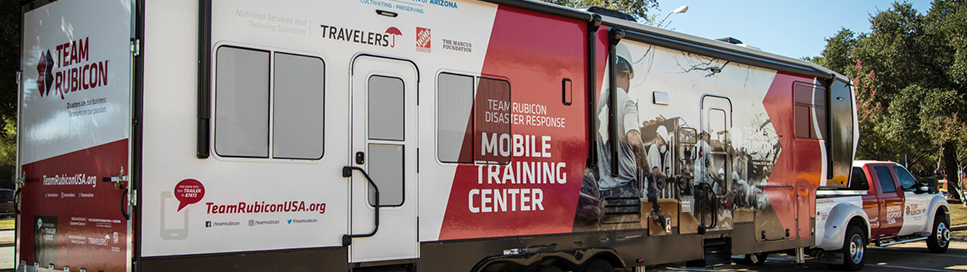 Team Rubicon truck with logo reading "mobile training center" parked in a parking lot.