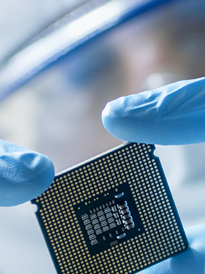 Close up of hands in latex gloves holding a computer chip.