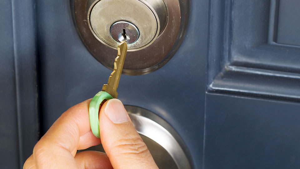 Person locking door before going on vacation.