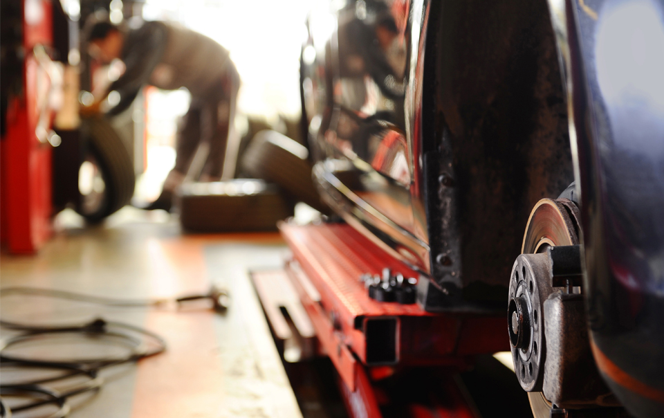 mechanic working on car brakes in a car repair shop