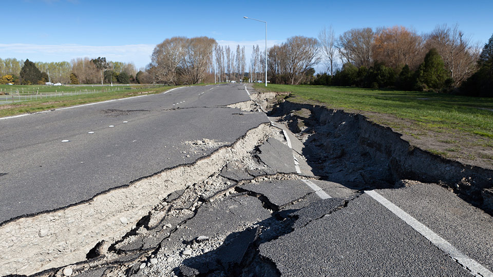 A big crack in the road caused by an earthquake.