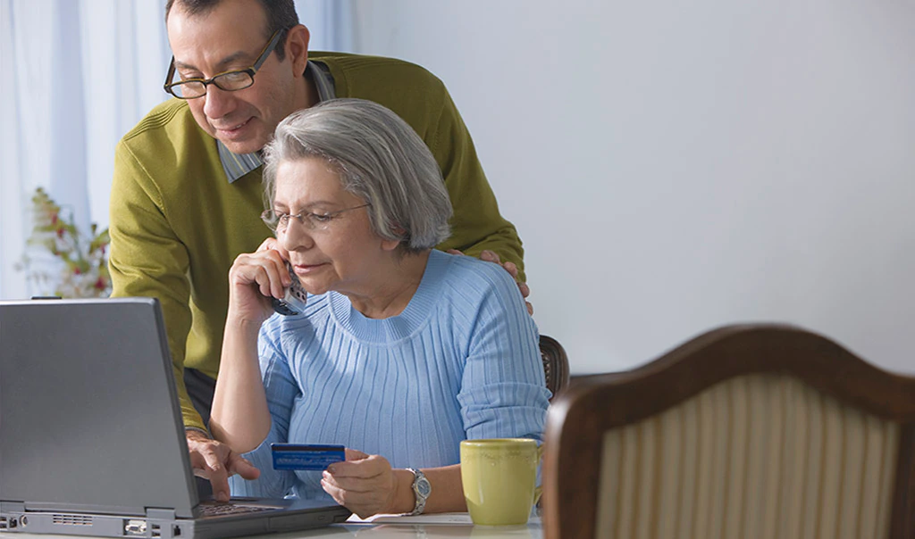 A man and woman entering credit card information safely on computer.