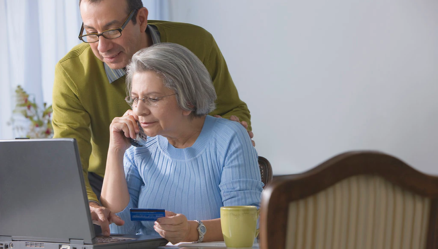 A man and woman entering credit card information safely on computer.